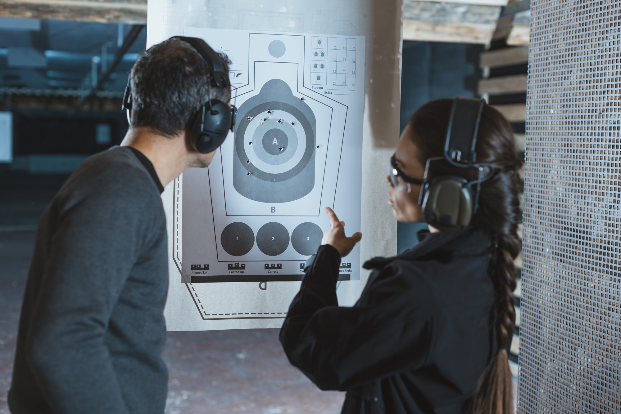 shooting-instructor-pointing-on-used-target-in-shooting-range.jpg